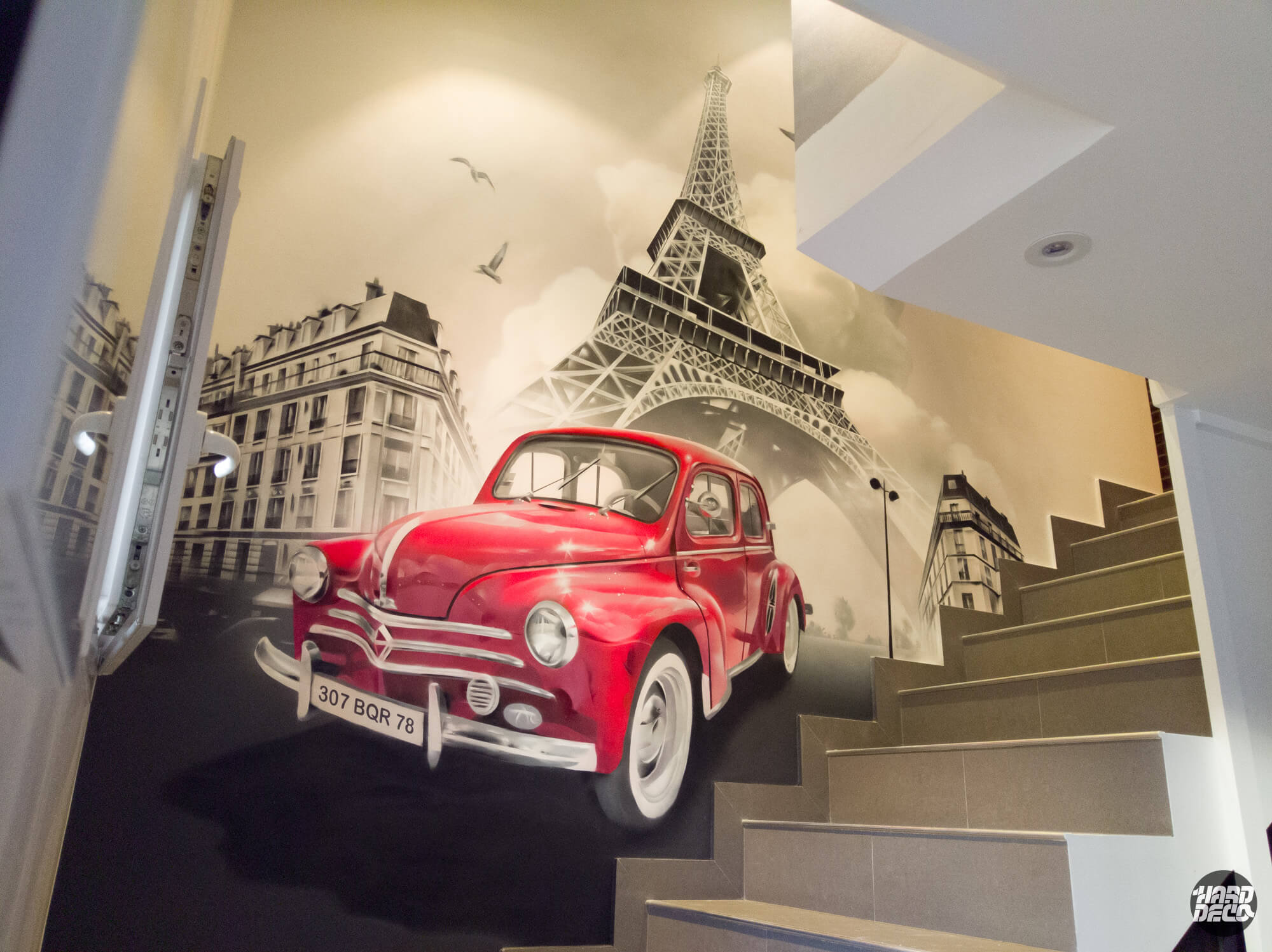Fresque aérosol cage d'escalier Renault 4CV rouge Tour Eiffel Paris noir et blanc, vue en contre-plongée
