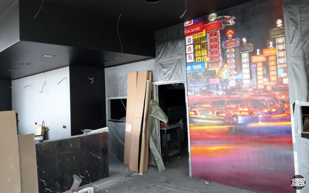 Vue d'ensemble du restaurant Mama Thai en chantier avec fresque murale Bangkok néons et trafic nocturne