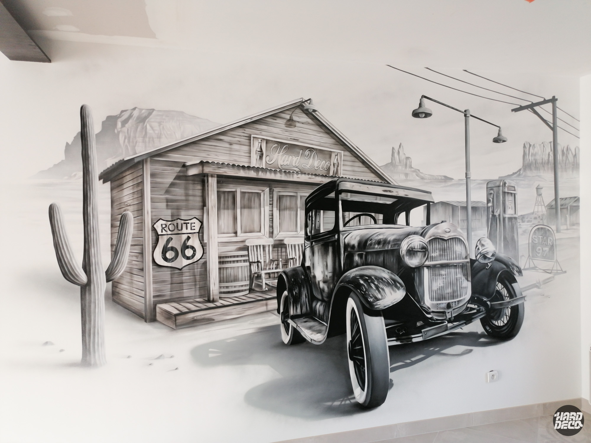 Fresque murale Route 66 en noir et blanc avec voiture ancienne et station-service dans un décor désertique