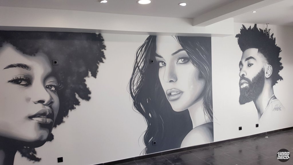 Fresque murale aérosol noir et blanc, trois portraits réalistes dans un salon de coiffure, vue rapprochée