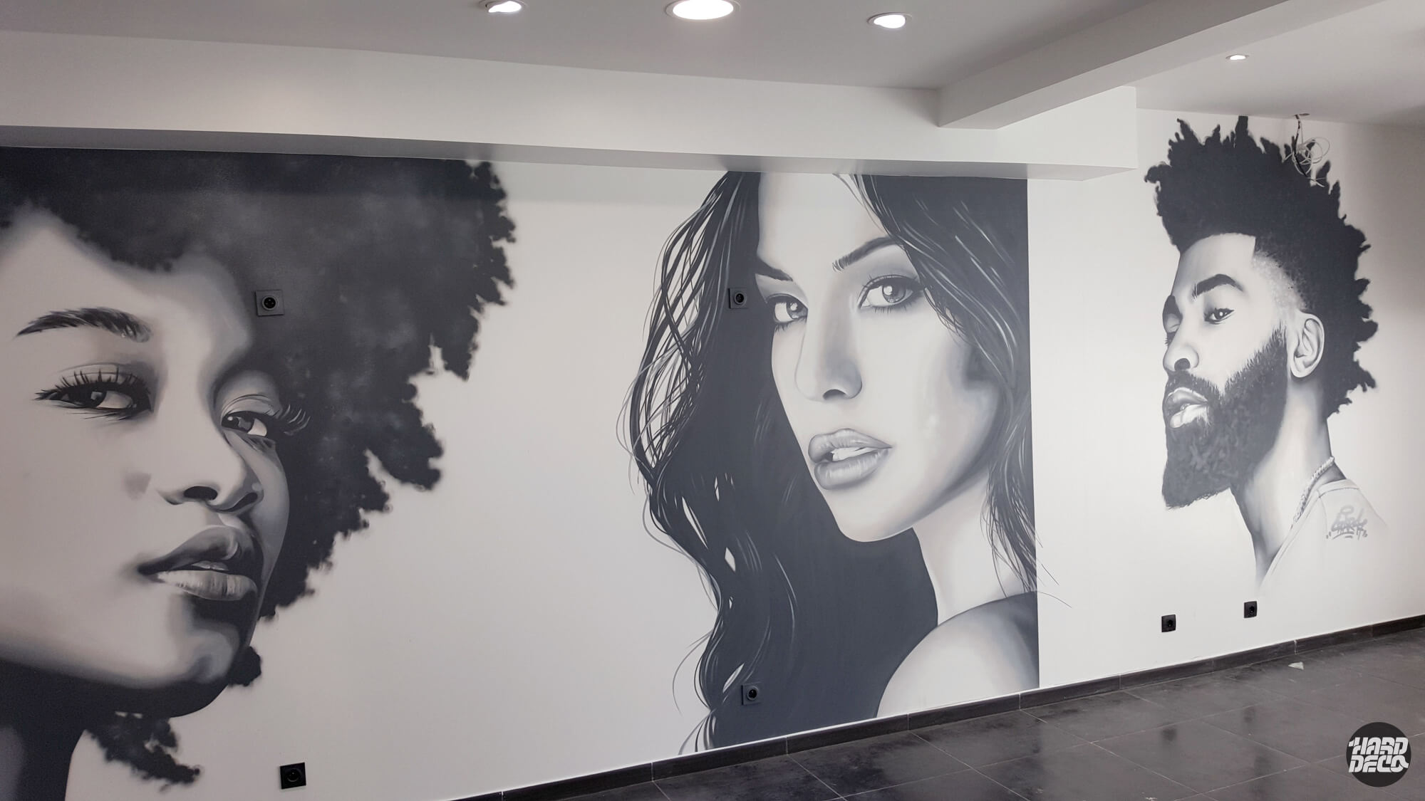 Fresque murale aérosol noir et blanc, trois portraits réalistes dans un salon de coiffure, vue rapprochée