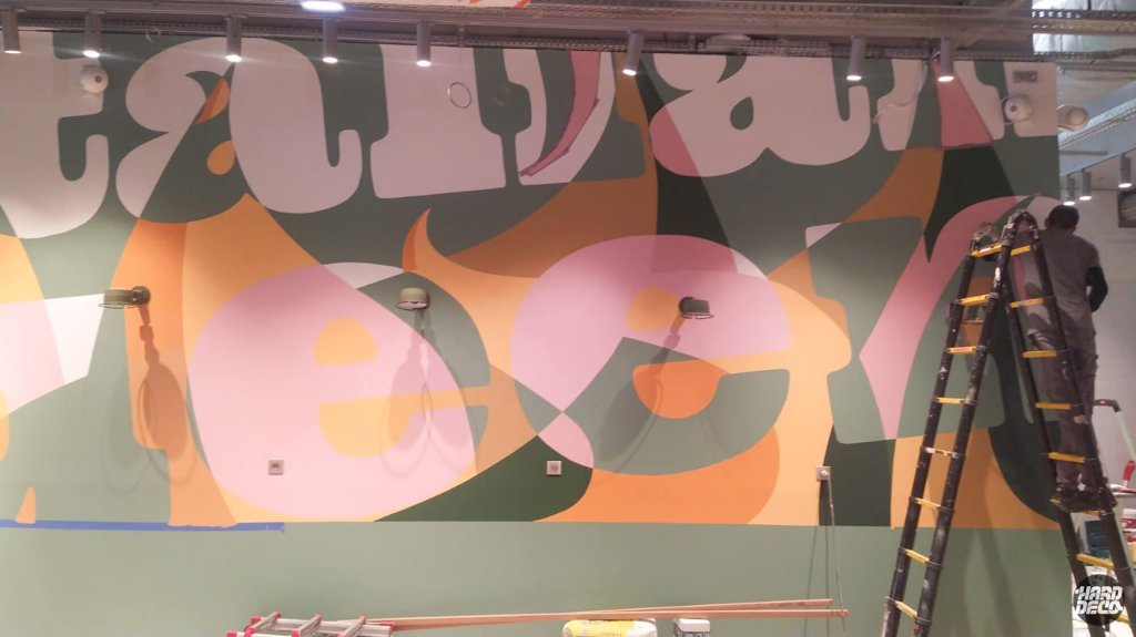 Réalisation en cours fresque Italian Queen Serris, artiste sur échelle peinture typographie flammes ambre