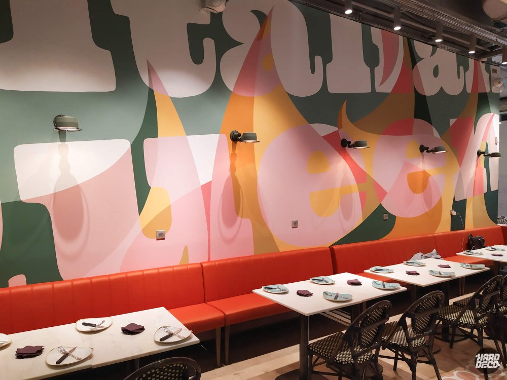 Fresque Italian Queen Serris, gros plan lettres monumentales rose et ocre sur fond vert sauge, salle vide