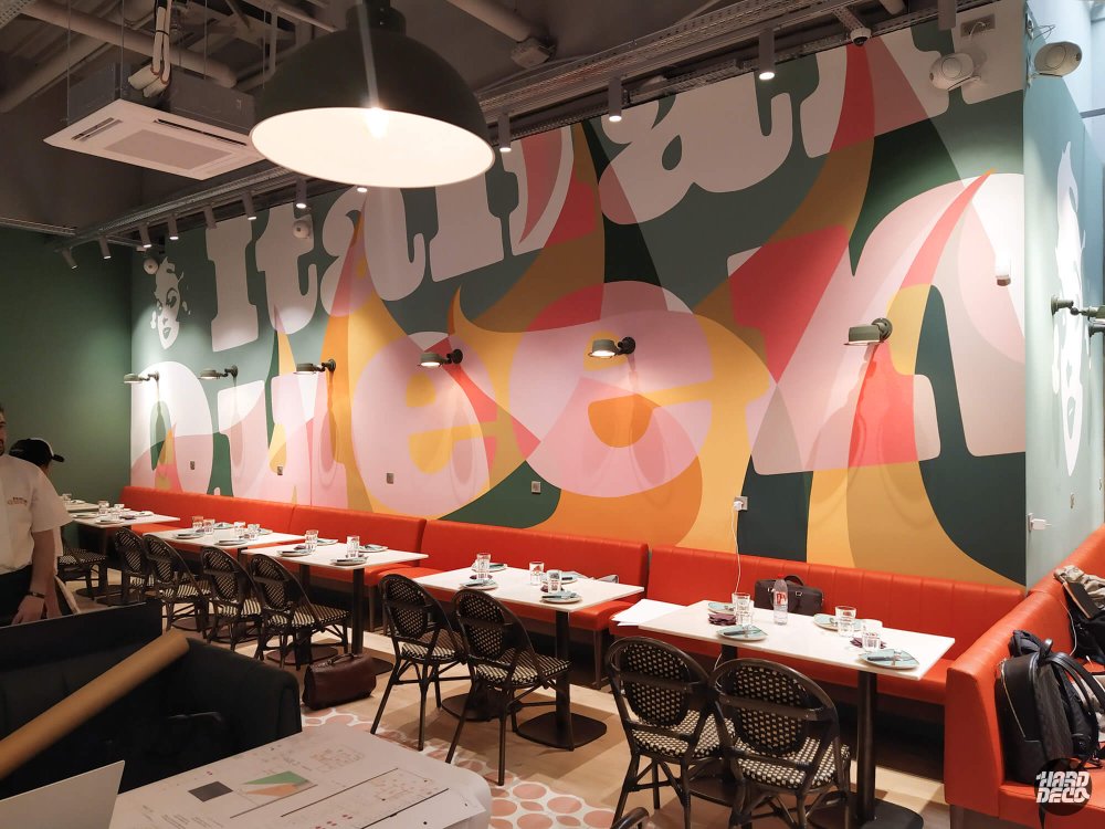Salle restaurant Italian Queen Serris, banquettes orangées et fresque typographique flammes rose ambre