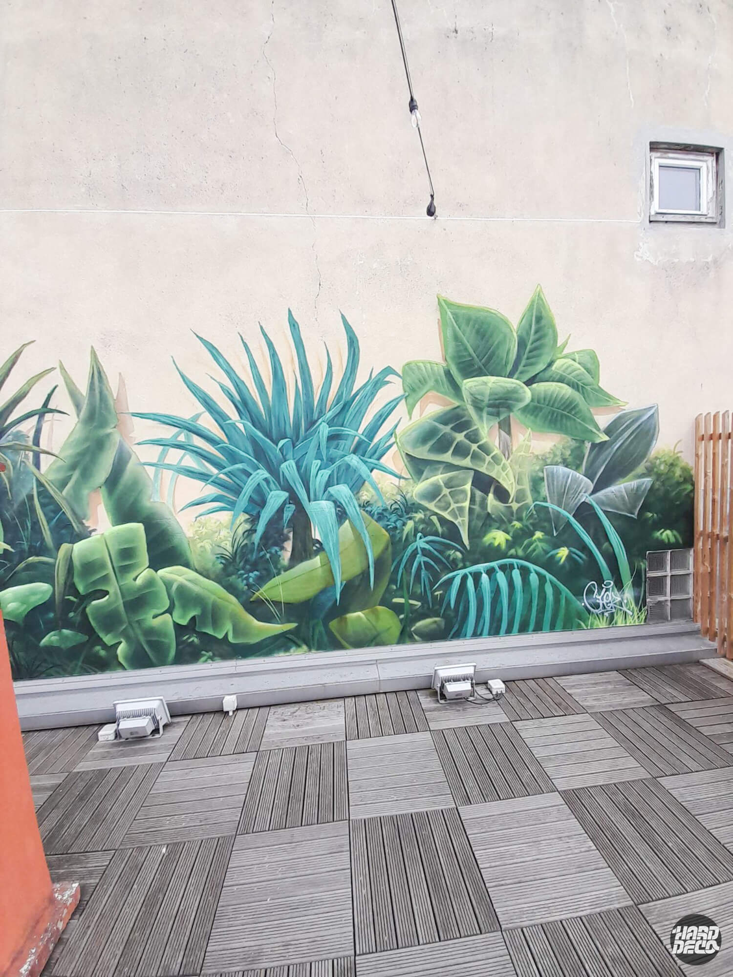 Fresque murale jungle aérosol sur terrasse extérieure, agaves et bananiers verts sur béton