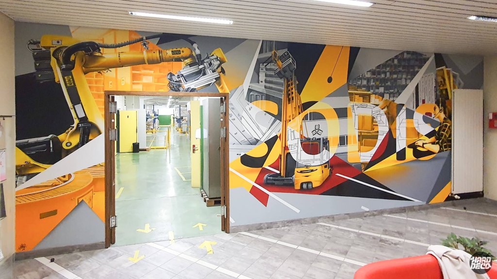 Fresque Sodis portes ouvertes sur couloir d'usine, composition aérosol robot industriel et chariot jaune
