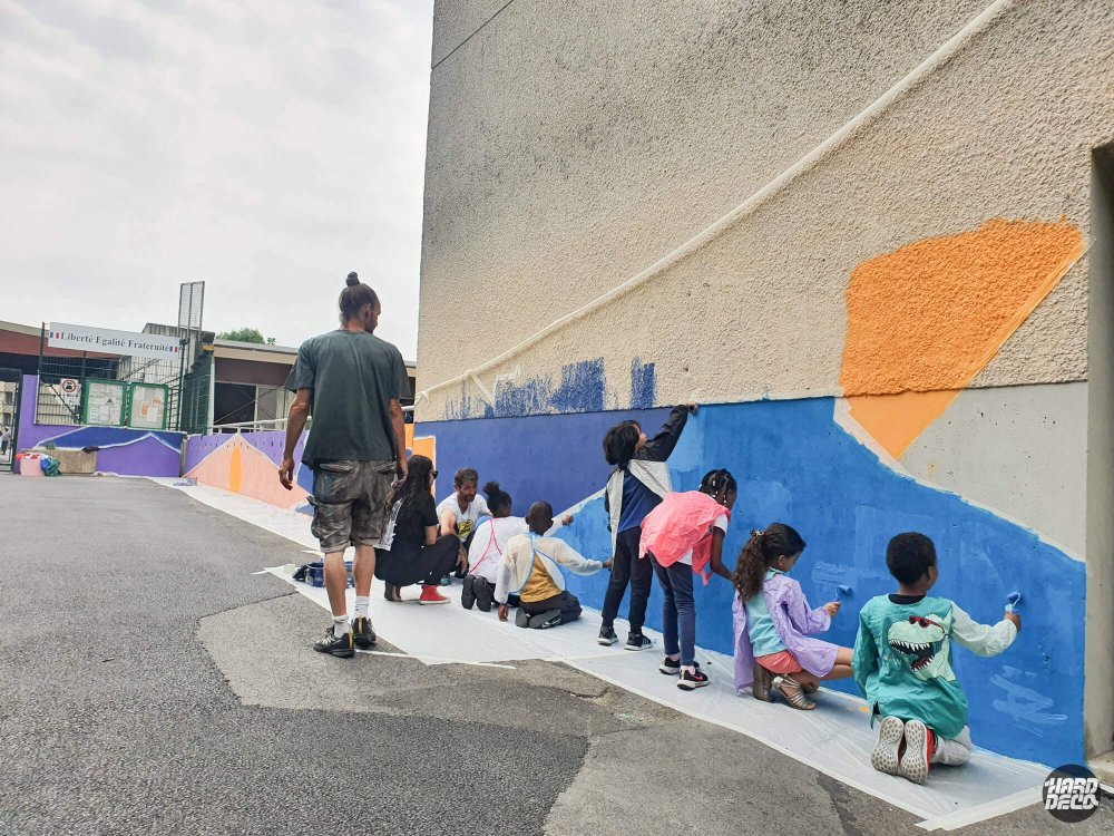 Élèves participant à la réalisation de la fresque murale avec l'artiste Samy dans la cour des écoles Victor Hugo, Torcy