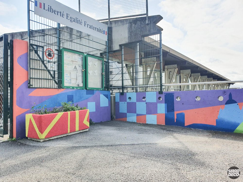 Fresque participative violet et rouge à l'entrée des écoles Victor Hugo de Torcy, motifs géométriques et damier