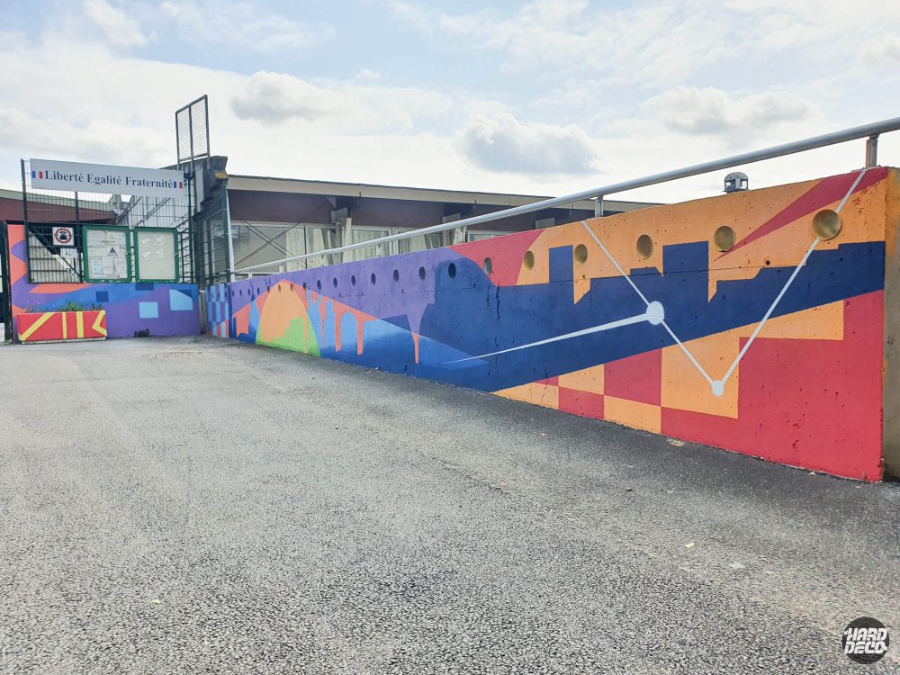Vue d'ensemble fresque murale colorée sur long muret extérieur école primaire Torcy, skyline abstraite et lignes blanches