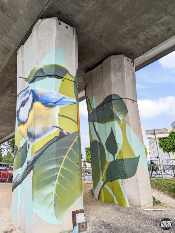 Mésange bleue et feuillage graphique sur deux piliers béton sous le viaduc RER A à Torcy, aérosol
