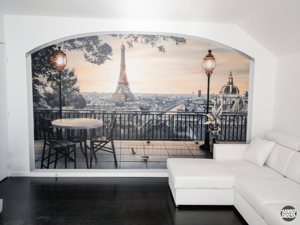 Fresque trompe-l'œil terrasse parisienne et tour Eiffel dans un salon blanc, angle légèrement décalé