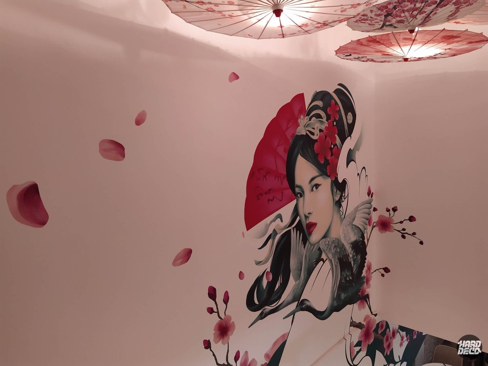 Décor mural japonais restaurant Kampai Versailles, geisha fond rose, pétales cerisier et ombrelles suspendues