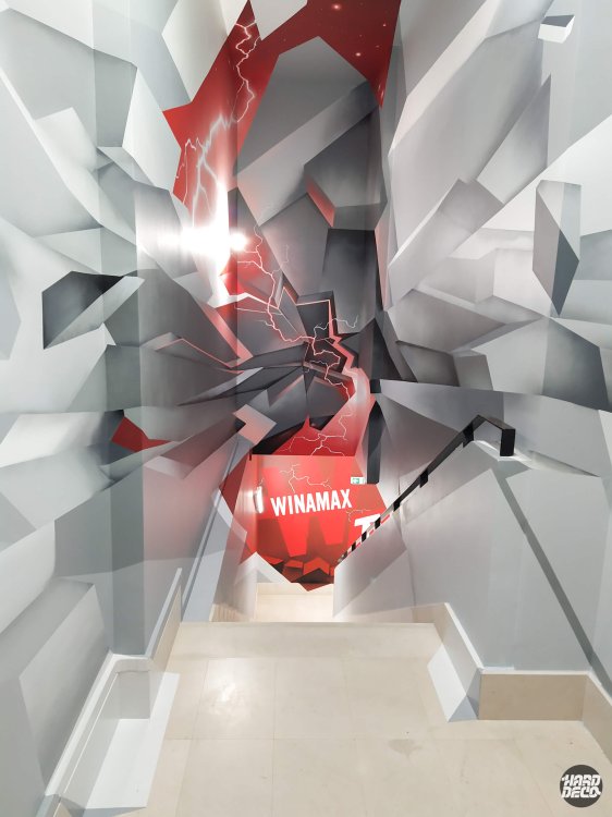 Vue descendante escalier Winamax TV, fresque géométrique 3D gris blanc rouge avec éclairs blancs