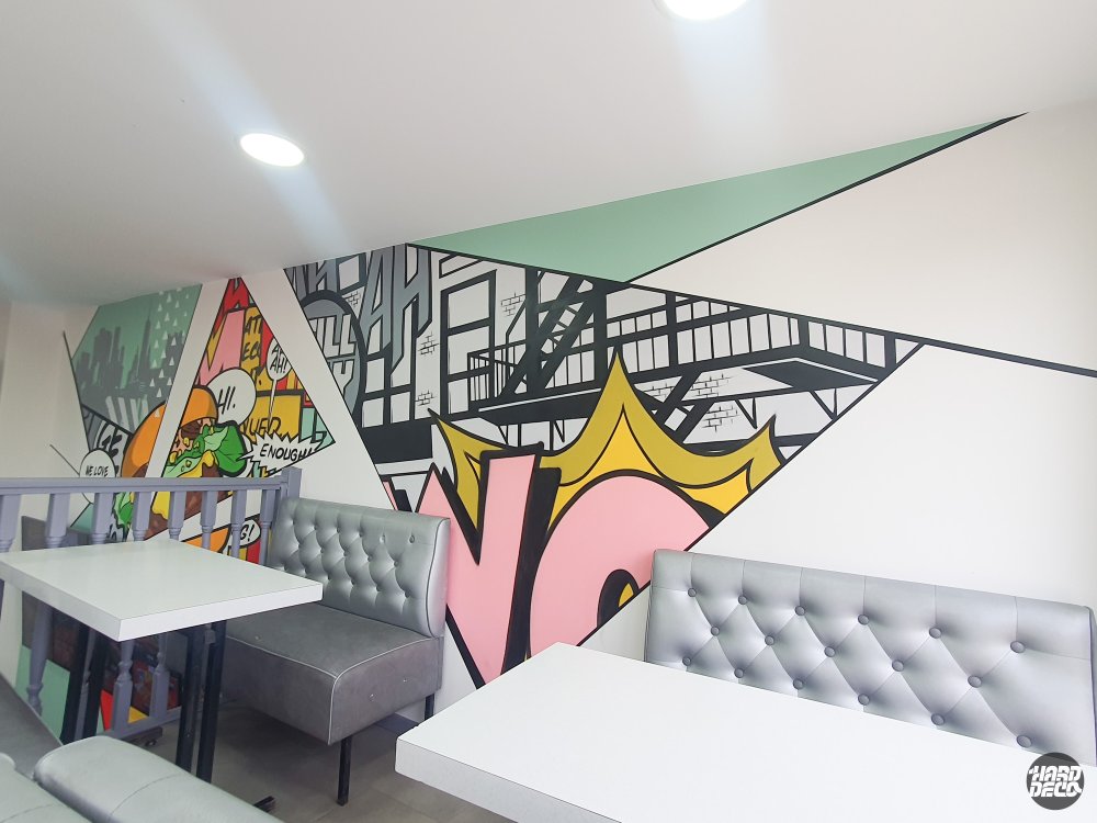 Fresque pop art aérosol salle restaurant Noisiel, cases BD avec lettrage rose et jaune, banquettes grises