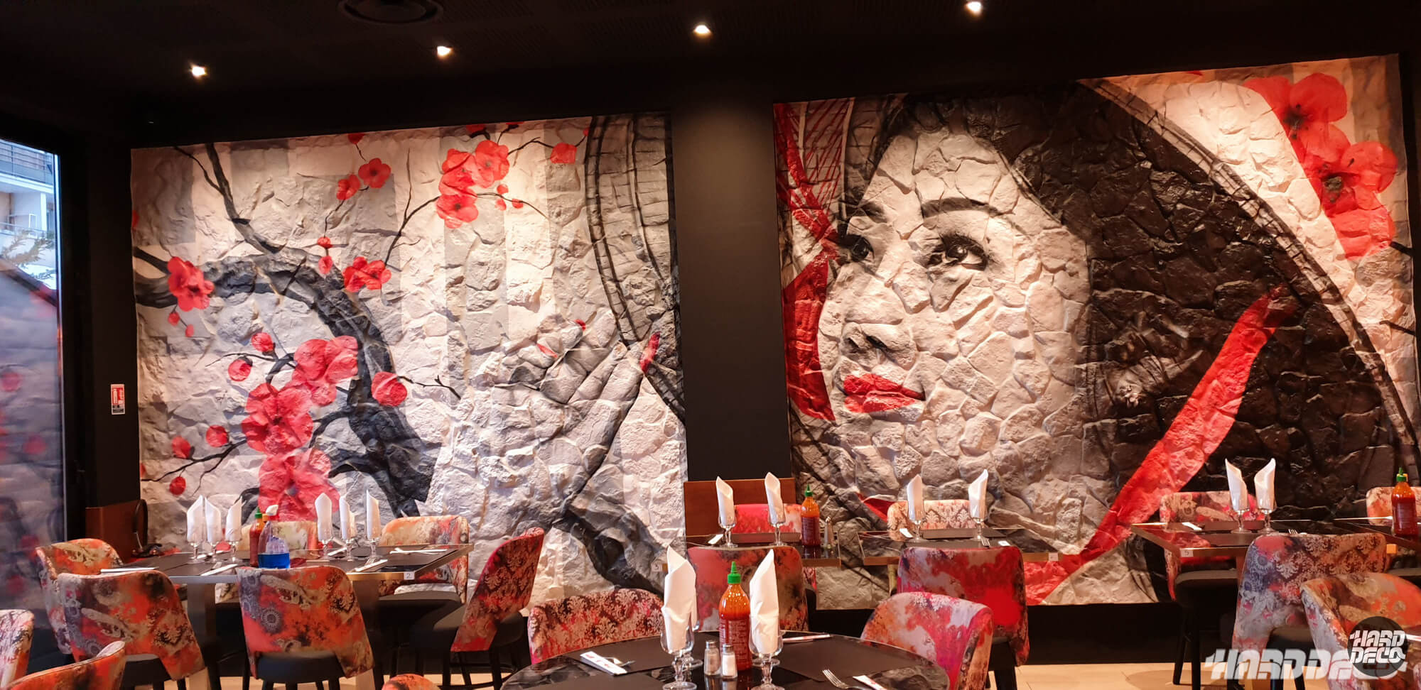 Fresque murale restaurant Tuk Tuk Torcy : portrait femme asiatique et fleurs rouges sur toiles texturées pierre
