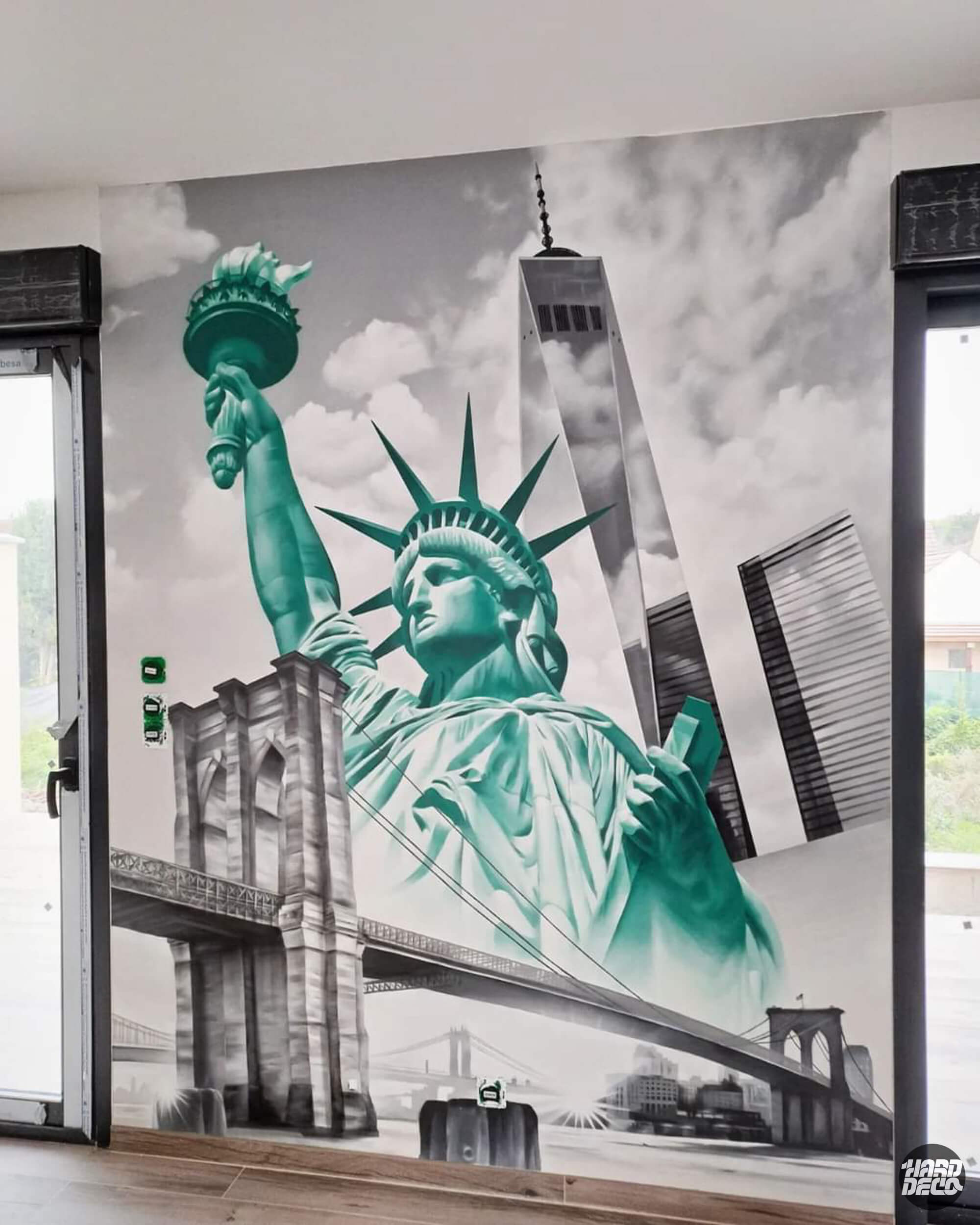 Gros plan sur fresque New York avec Statue de la Liberté en vert et Brooklyn Bridge en gris sur toile murale