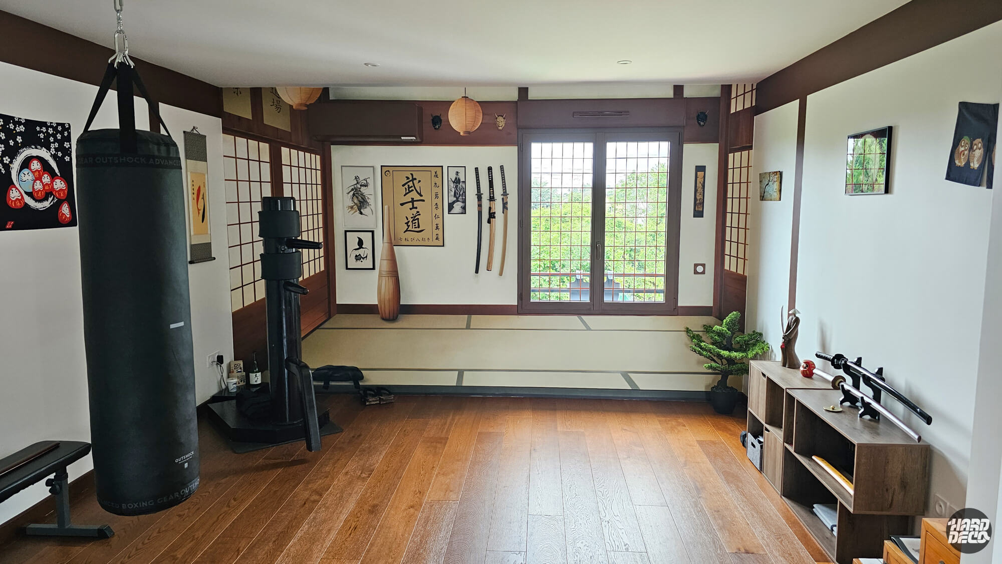 Salle de sport transformée en dojo japonais par trompe-l'œil : poutres brun-acajou, tatamis et katanas suspendus