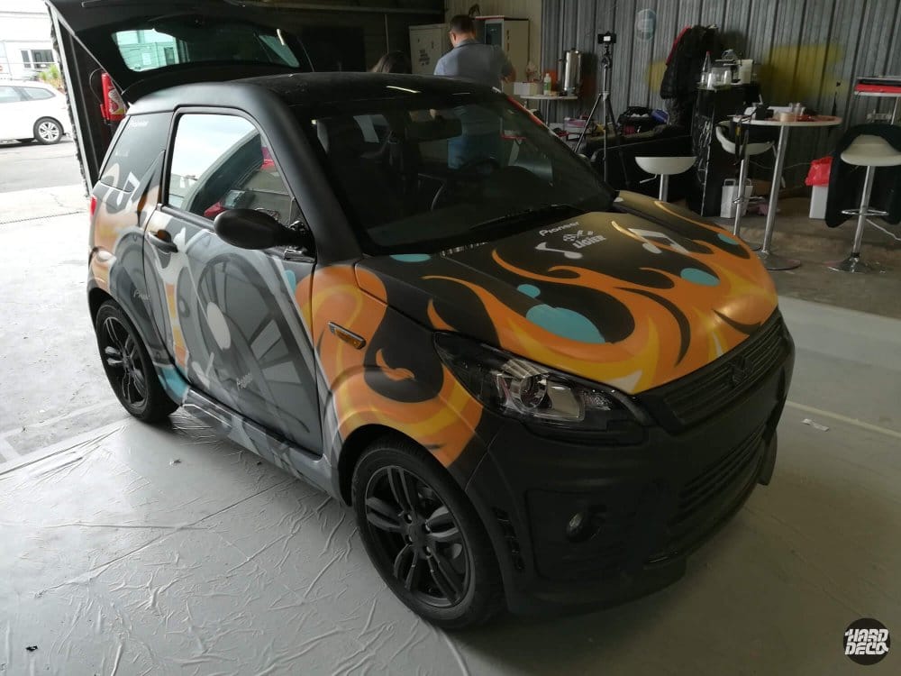 Voiture Ligier peinte à l'aérosol, capot avec flammes orangées et turquoise, partenariat Pioneer
