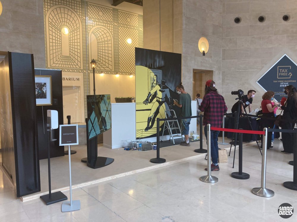 Live painting Batman et Joconde en cours de réalisation dans le hall du Louvre, événement Batman The World