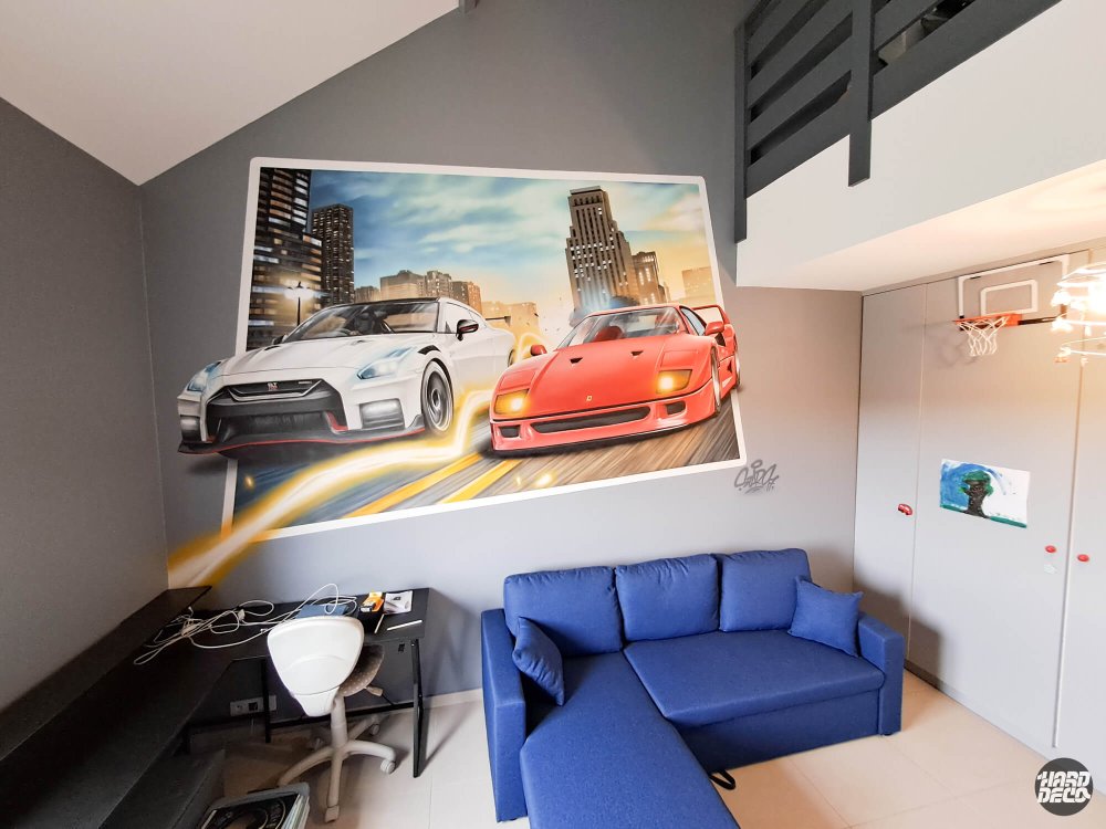Toile aérosol Ferrari F40 et Nissan GT-R en course urbaine, installée dans un salon sous mezzanine