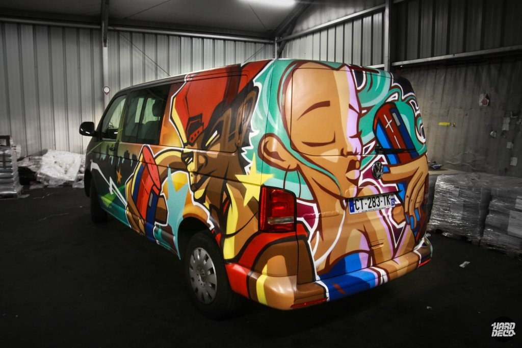 Vue arrière van UE Boom décoré à l'aérosol par Shero, portrait figuratif et composition street art multicolore