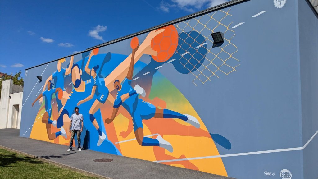 Vue d'ensemble fresque handball 54 m² façade gymnase Pontault-Combault avec artiste Shero et logo PCHB