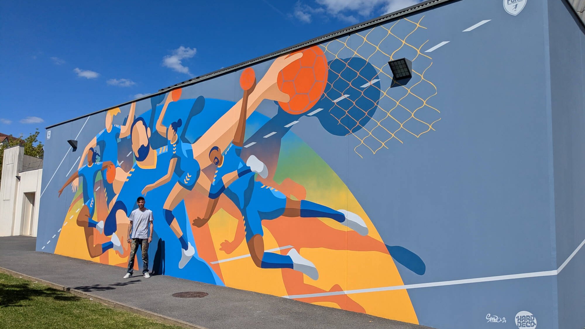 Vue d'ensemble fresque handball 54 m² façade gymnase Pontault-Combault avec artiste Shero et logo PCHB