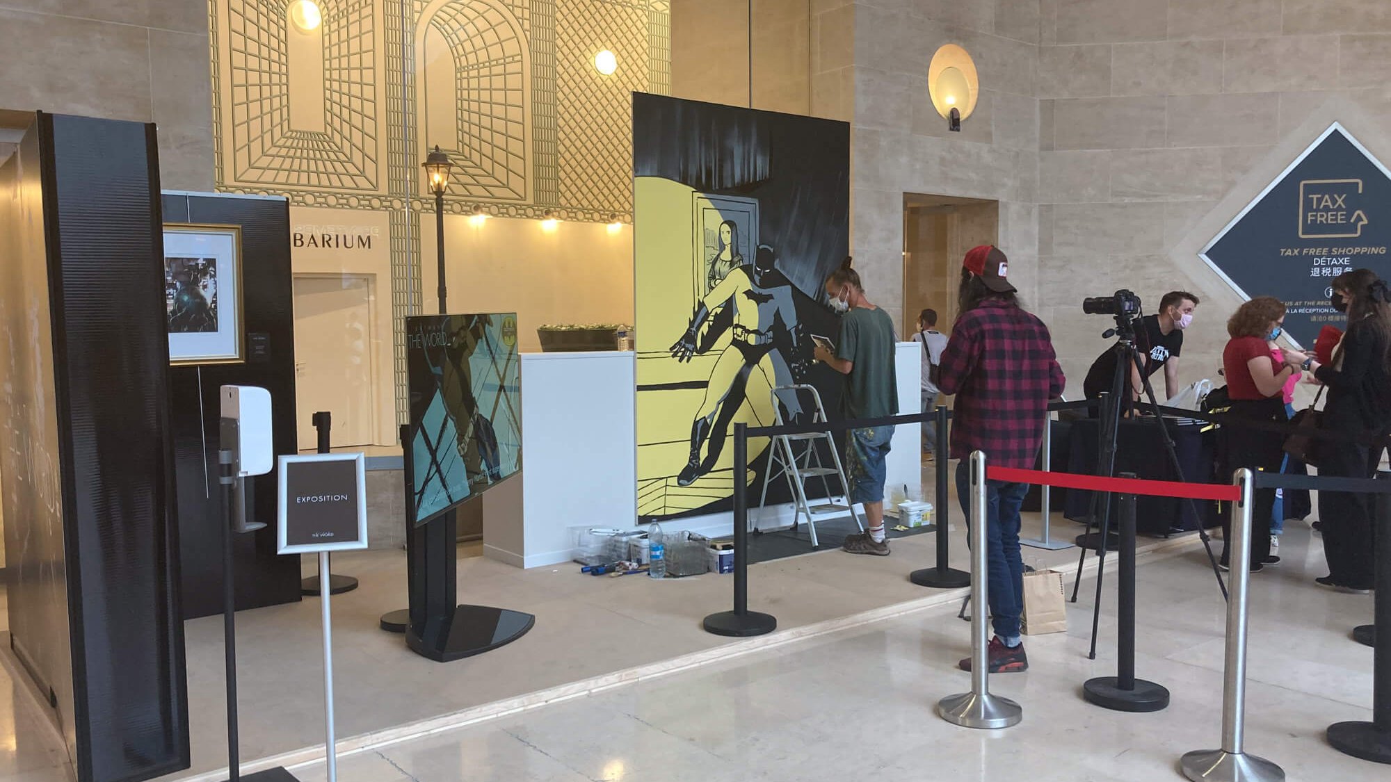 Live painting Batman et Joconde en cours de réalisation dans le hall du Louvre, événement Batman The World
