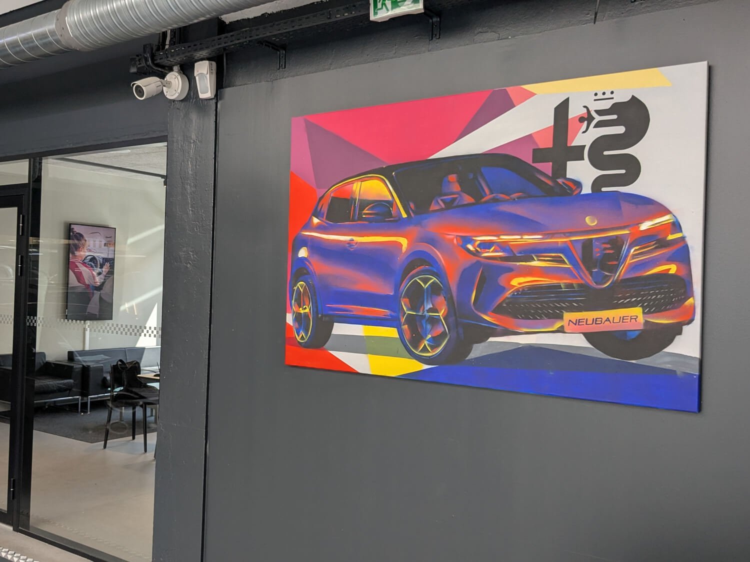 Peinture décorative représentant une voiture colorée avec effets de lumière sur un panneau mural dans un bureau moderne