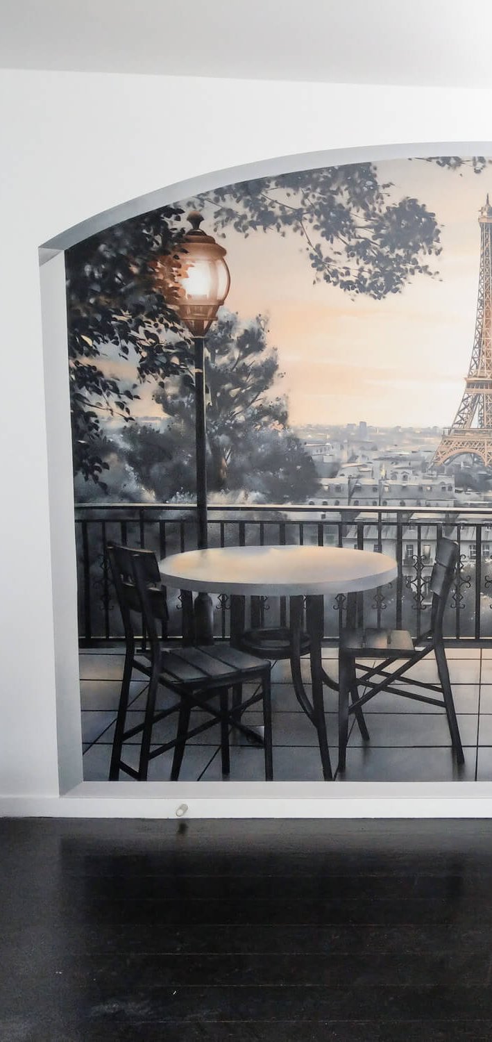 Trompe-l'œil balcon parisien avec tour Eiffel peint à l'aérosol dans un salon, vue d'ensemble